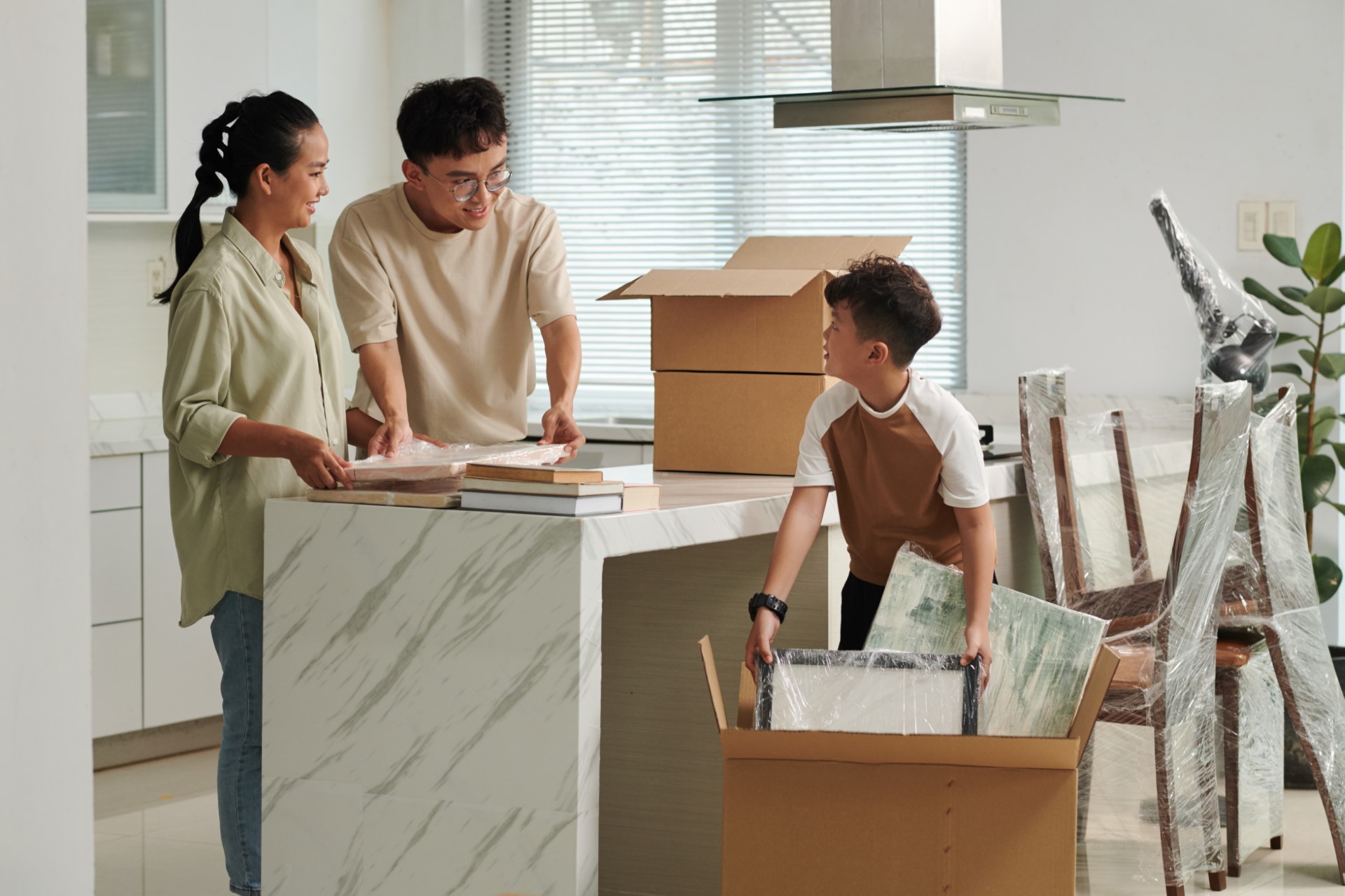 Family unpacking moving boxes in their kitchen