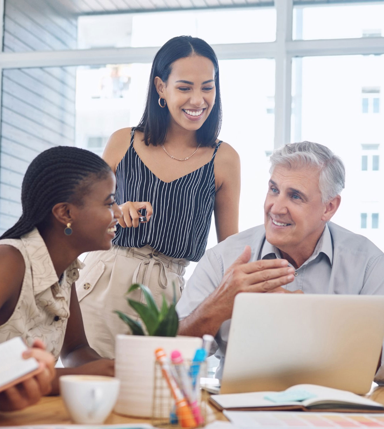 Colleagues talking together around a laptop